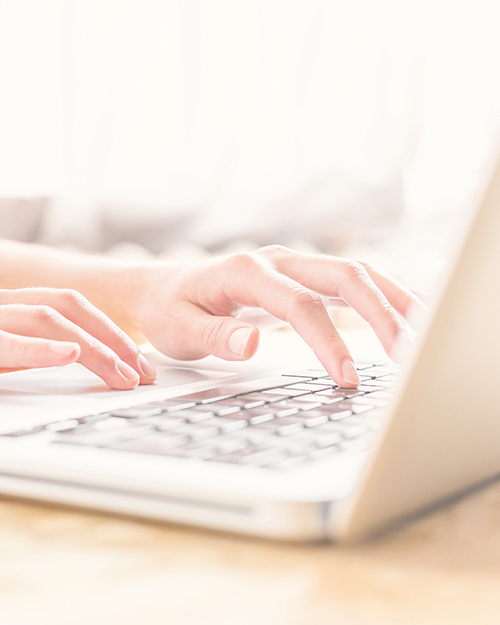 Close up of typing female hands at home office.